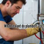 Focused plumber sealing a pipe leak.